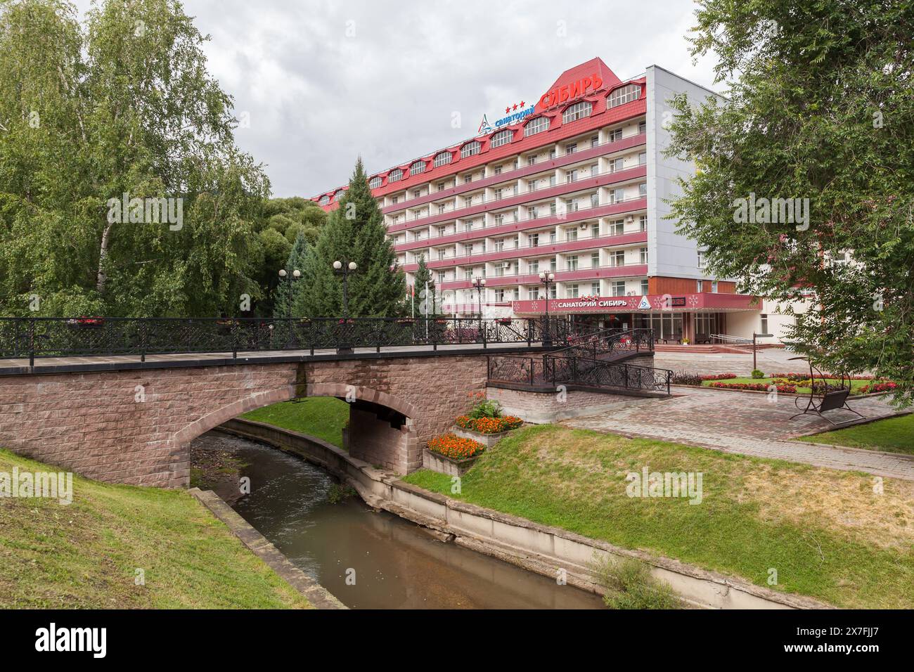 Belokurikha, Russland - 19. August 2022: Belokurikha Resort Stadtlandschaft mit kleiner Fußgängerbrücke und Gebäuden des sibirischen Sanatoriums. Russischer Tex Stockfoto