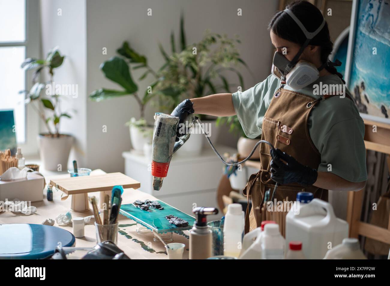 Der Künstler arbeitet mit fließfähigem Epoxidharz, erstellt im Atelier Gemälde mit einem thermischen Trockner Stockfoto