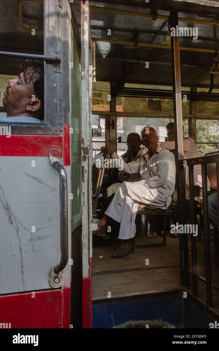 Indien, New Dehli - 24 10 2017: Indische Männer sitzen im Bus. Schlafender Mann und Fahrgäste im Bus. Stadtverkehr in Indien. Indische Kultur. Stockfoto