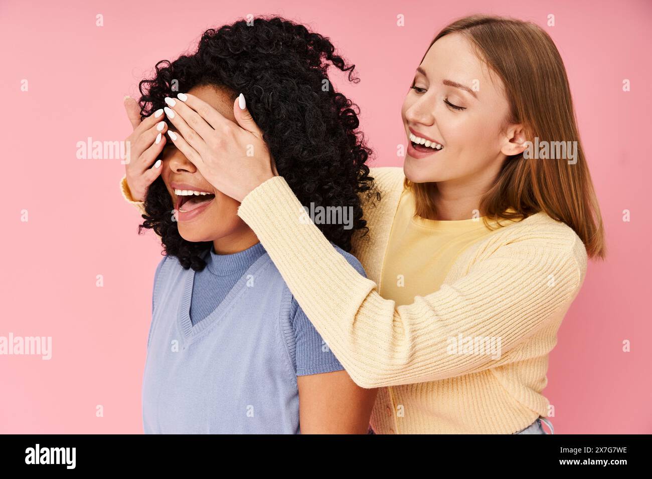 Zwei Frauen in legeren Kleidern, die lachen und Zeit miteinander verbringen. Stockfoto