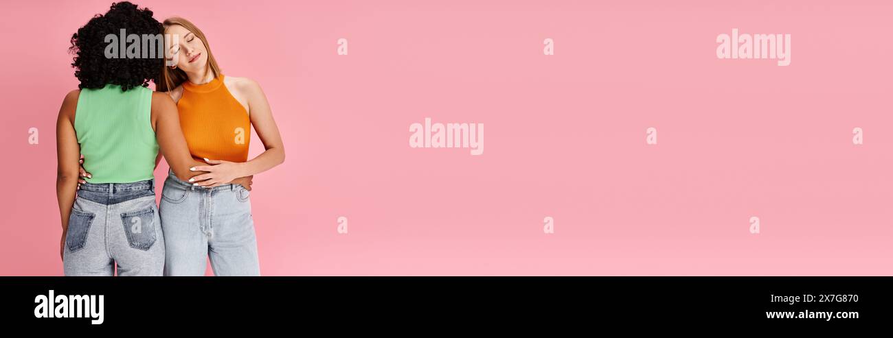 Zwei attraktive, vielfältige Frauen in kuscheliger Freizeitkleidung stehen zusammen. Stockfoto