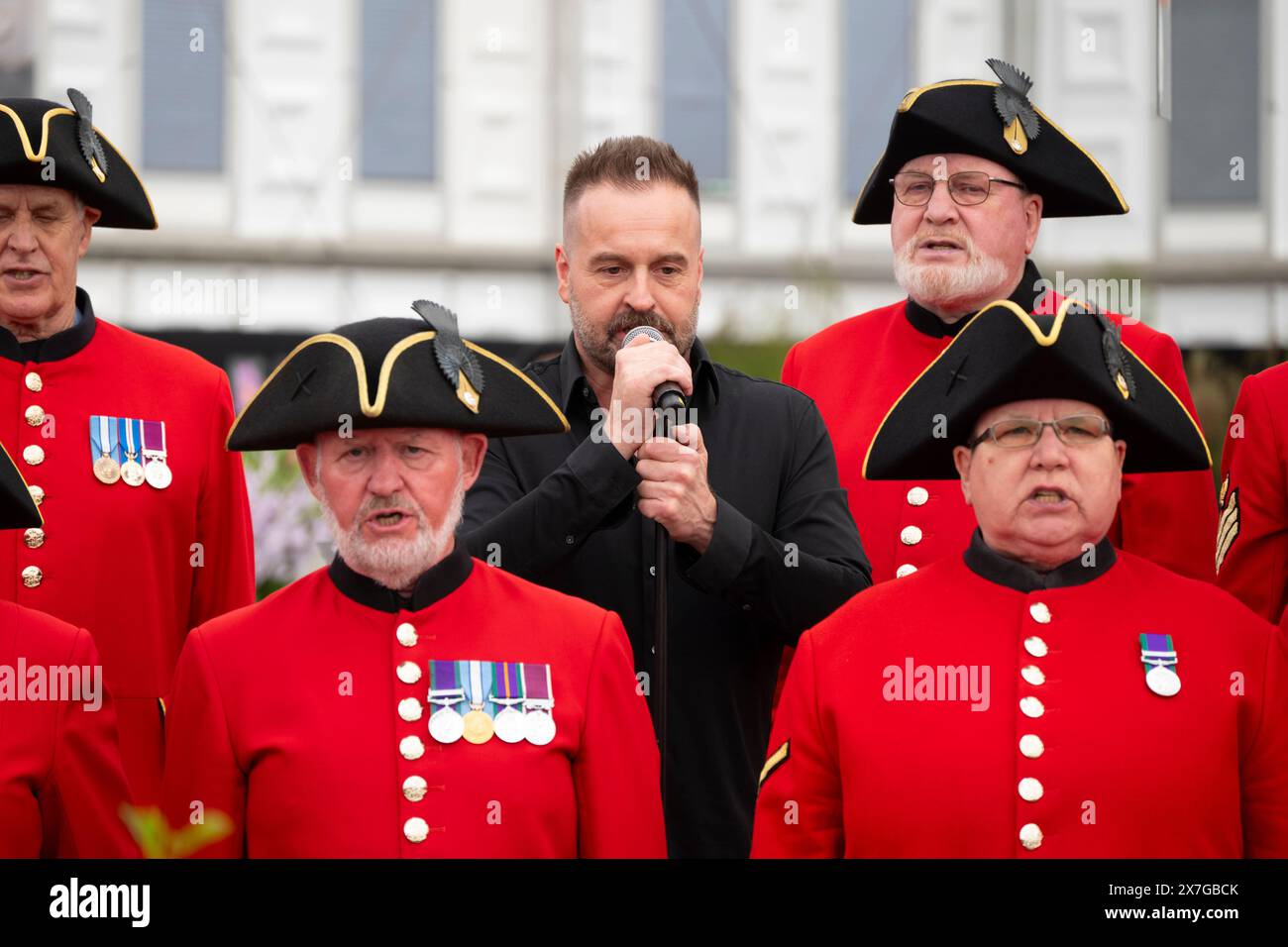 Royal Hospital, Chelsea, London, Großbritannien. Mai 2024. Presse- und VIP-Tag auf der RHS Chelsea Flower Show 2024, die vom 21. Mai bis 25. Mai für die Öffentlichkeit geöffnet wird. Bild: Alfie Boe wird von der Chelsea Pensioners Singing Group begleitet, um Bette Midlers „The Rose“ auf dem Harkness Roses 1879 Stand im Great Pavilion aufzuführen. Quelle: Malcolm Park/Alamy Live News Stockfoto