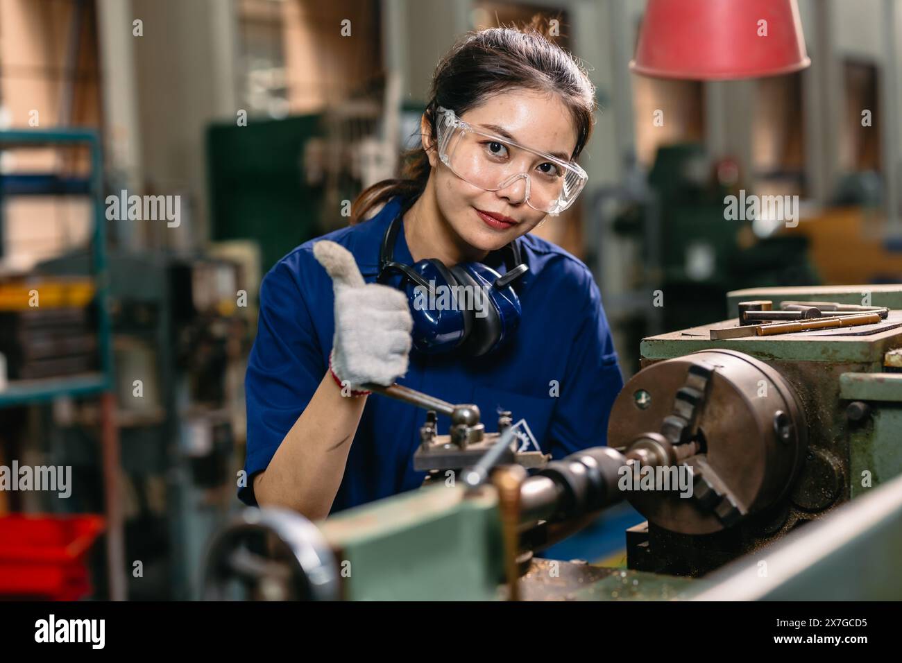 Porträt glücklicher Ingenieur Arbeiter mit Sicherheitsaugen Schutz Brille professionell arbeiten mit Metalldrehmaschine Fräsmaschine Schwerindustriefabrik. Stockfoto
