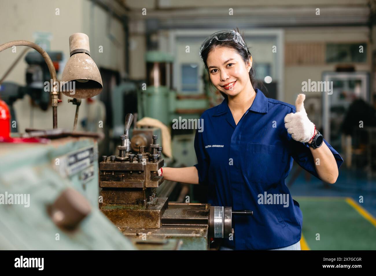 Porträt glücklicher Ingenieur Arbeiter mit Sicherheitsaugen Schutz Brille professionell arbeiten mit Metalldrehmaschine Fräsmaschine Schwerindustriefabrik. Stockfoto