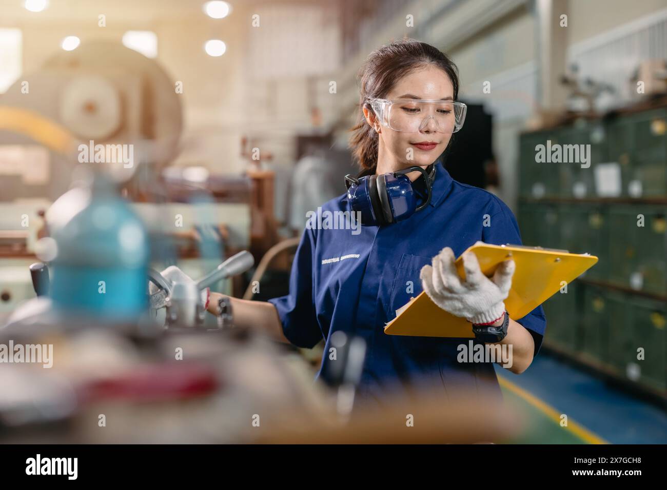 Professioneller Ingenieur Arbeiter mit Sicherheitsaugenschutz Fokus, der in Metalldrehmaschine Fräsmaschine Schwerindustriefabrik arbeitet. Stockfoto