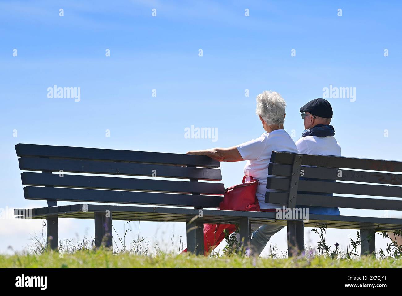 Aelteres Ehepaar-Rentner -Mann und Frau sitzt auf einer Bank im Freien. *** Älteres Ehepaar im Ruhestand, Mann und Frau, die draußen auf einer Bank sitzen Stockfoto