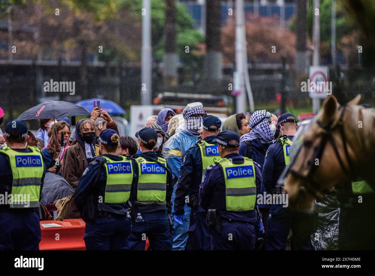 Polizeibeamte halten eine Schlange, während sie Pro-palästinensische Anhänger beobachten, die von der Pro-jüdischen Kundgebung getrennt sind. Sechs Personen wurden verhaftet, nachdem sich pro-palästinensische und pro-israelische Demonstranten in Melbournes CBD heftig ausgetauscht hatten. 7000 Personen nahmen an der Nakba Sunday Rallye Teil und eine Never Again is Now Rallye, die von der christlich-zionistischen Gruppe International Christian Embassy Jerusalem organisiert wurde. Es hat einige Demonstranten von der Nakba Sunday Rallye, die um Mittag um die Staatsbibliothek herum begann, in die Spring St fusionierten, um das Parlamentsgebäude, wo die Never Aga Stockfoto