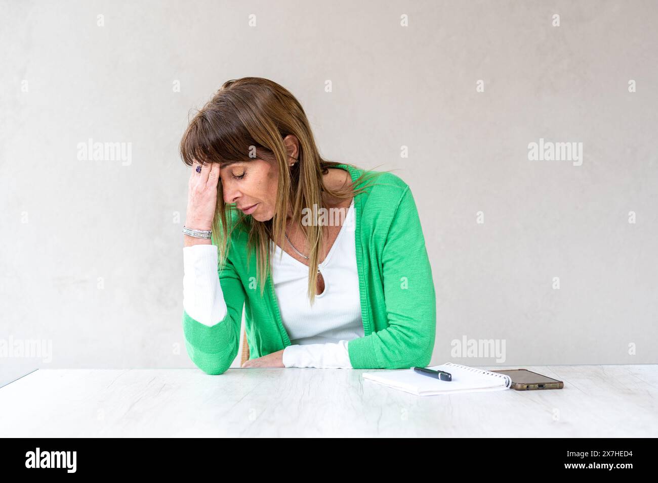 Eine Frau im mittleren Erwachsenenalter hat wegen Kopfschmerzen aufgehört zu arbeiten Stockfoto