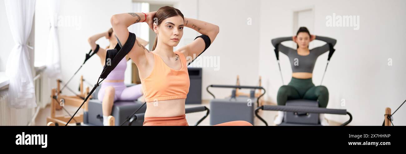 Eine Gruppe von ziemlich sportlichen Frauen, die Pilates-Übungen in einem Fitnessstudio machen. Stockfoto