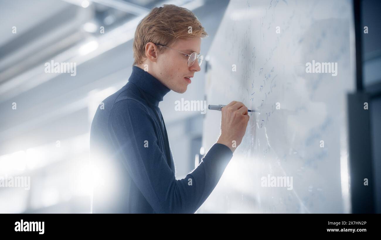 Intelligent Young Academic Writing große und komplexe mathematische Formel oder Gleichung auf dem Whiteboard. Problemlösung und Suche nach neuen effizienten Strategien. Stockfoto
