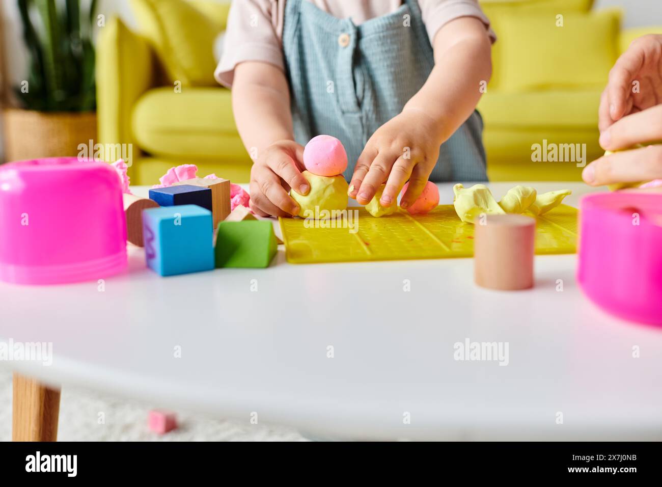 Eine Mutter führt ihr kleines Mädchen durch Montessori und lernt mit bunten Blöcken und Formen. Stockfoto