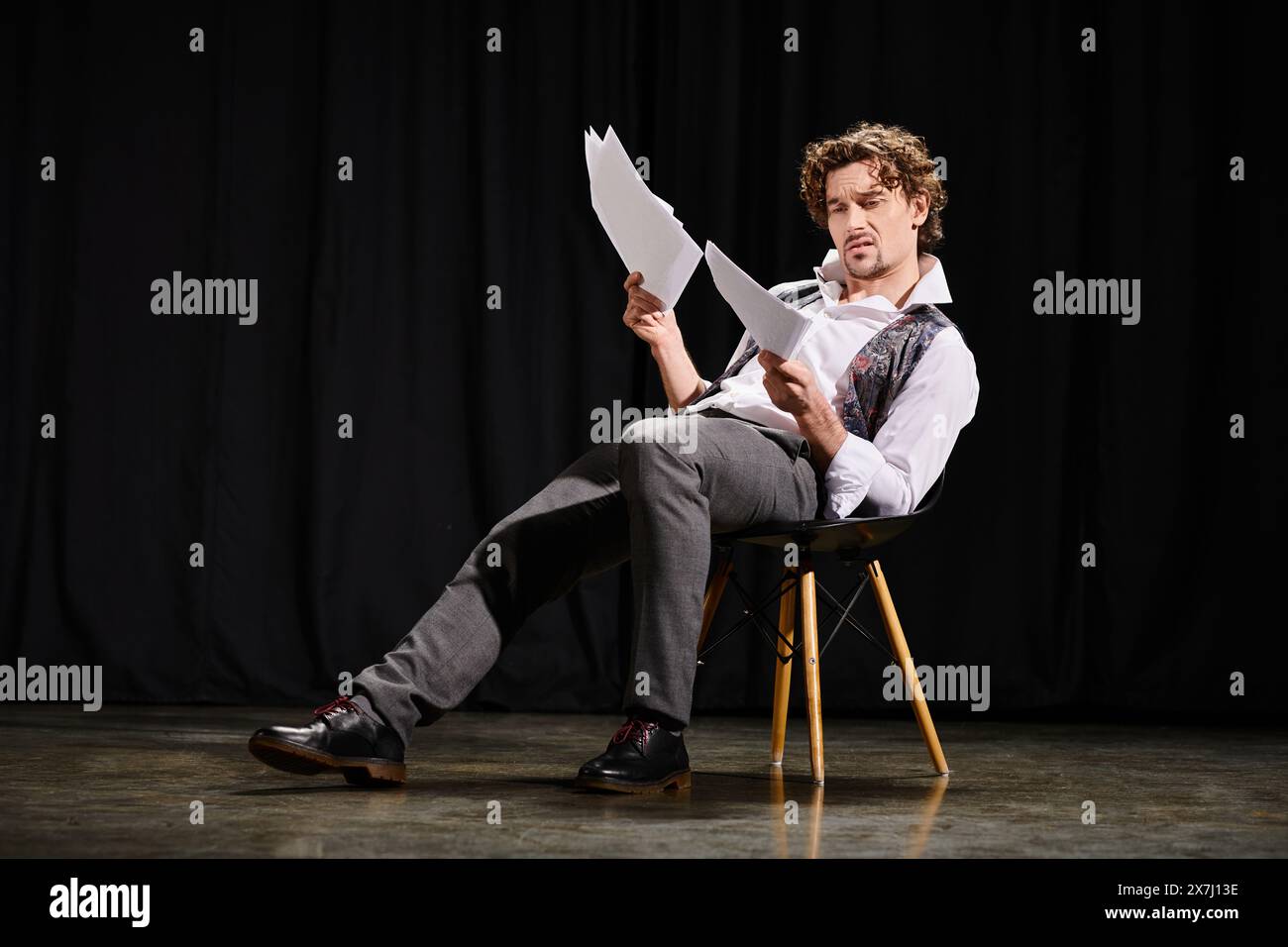 Ein Mann, der in einem Stuhl saß, ein Drehbuch zu lesen. Stockfoto Ein Mann, der in einem Stuhl saß, ein Drehbuch zu lesen. Stockfoto