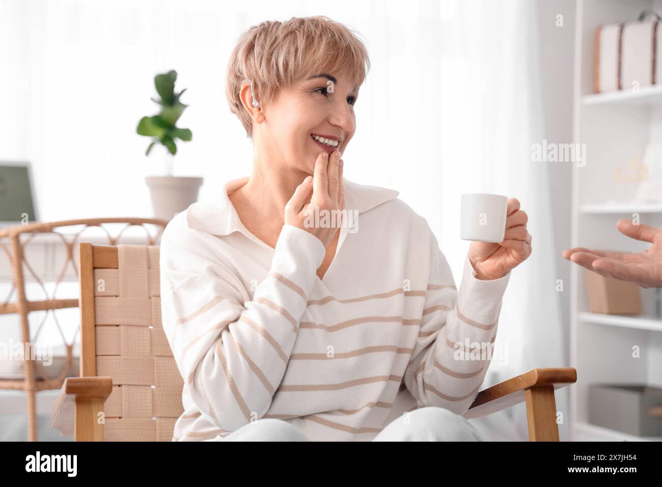 Reife, taube, stumme Frau mit einer Tasse Kaffee und ihr Mann verwendet zu Hause Gebärdensprache Stockfoto