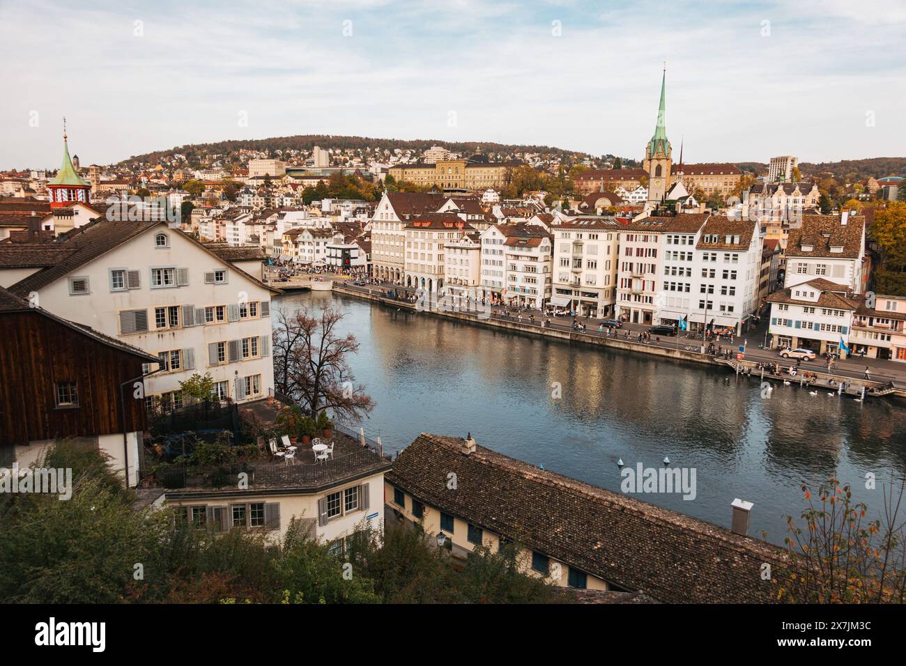 Zürcher Limmat an einem ruhigen Herbsttag mit alten Gebäuden am Ufer und hinter dem Turm der Zentralbibliothek sichtbar Stockfoto