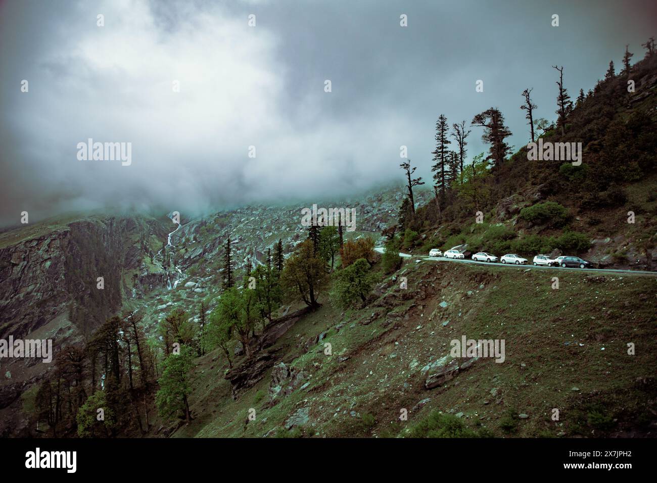 Ein majestätisches Panorama des schneebedeckten Himalaya in Himachal Pradesh, mit üppigen grünen Tälern und nebeligen Gipfeln, die den Himmel küssen. Friedliche Dörfer säumen das ganze Stockfoto