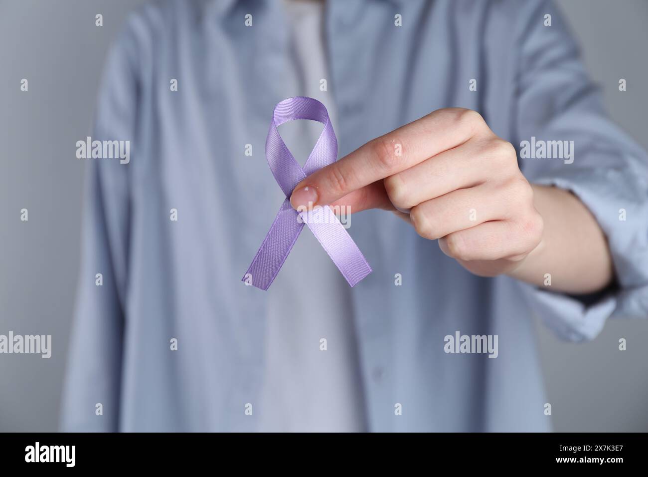 Frau mit violettem Sensibilisierungsband auf grauem Hintergrund, Nahaufnahme Stockfoto