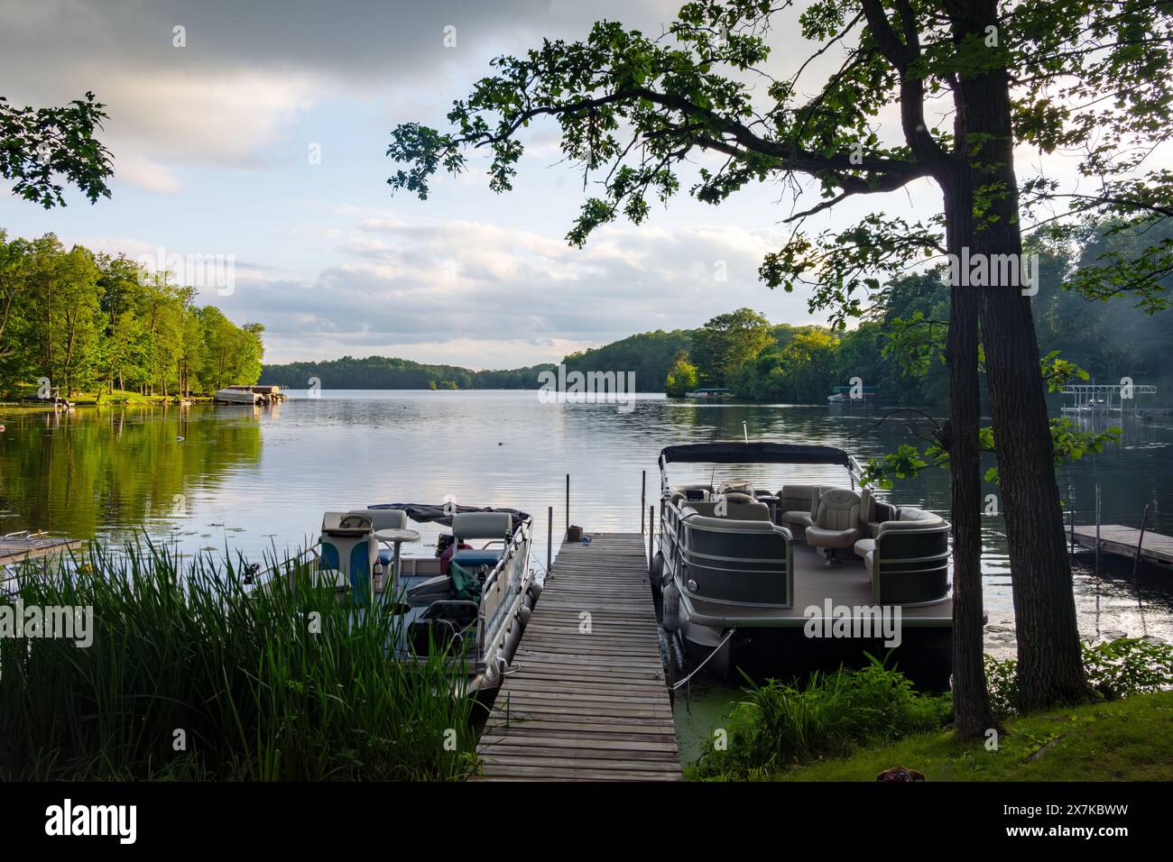 Blick auf einen See in Wisconsin northwoods, während die letzten Sonnenstrahlen verblassen. Viele Pontonboote sind abends vom Fischen zurückgekehrt Stockfoto