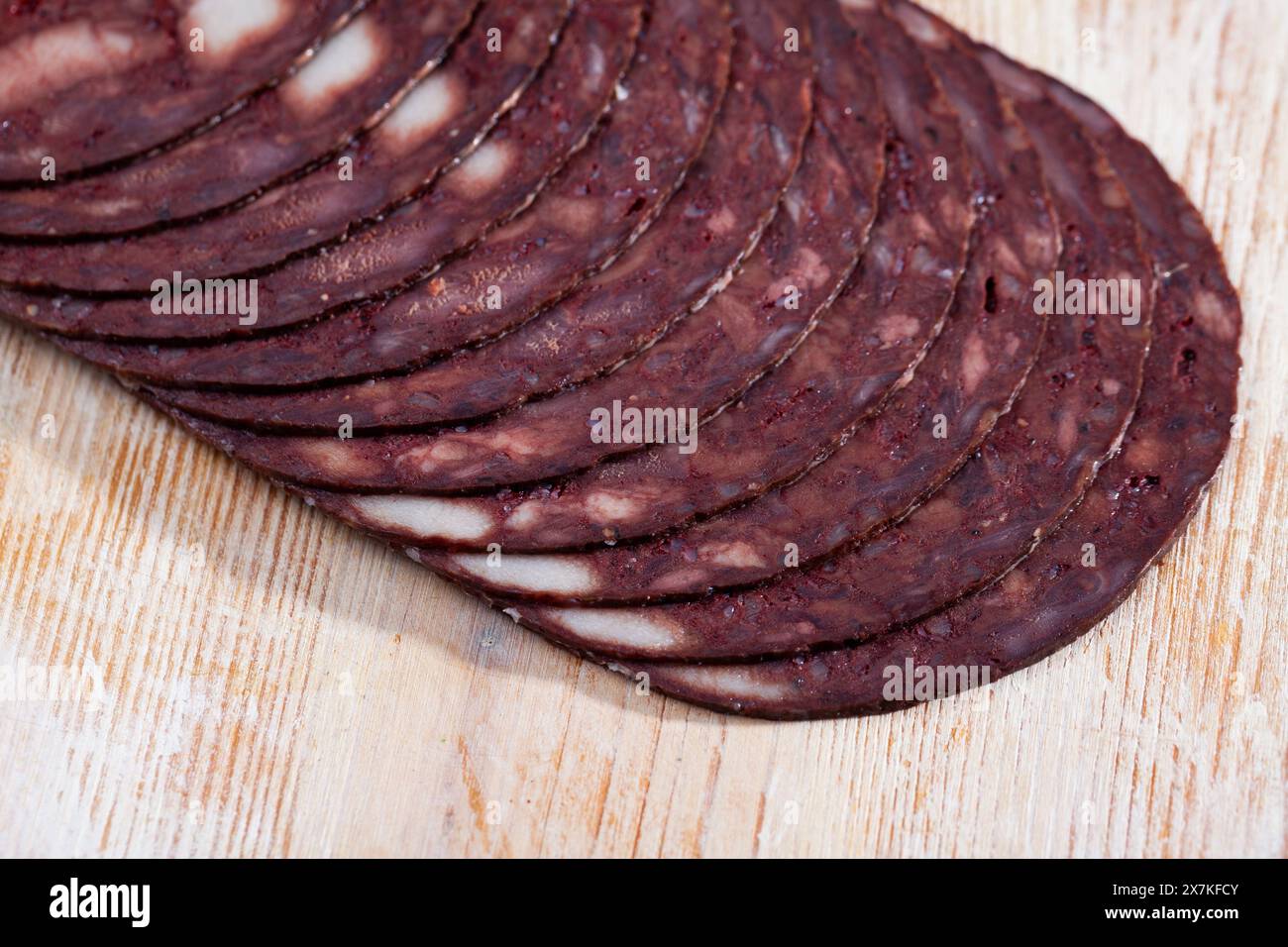 Dünne Scheiben katalanischer schwarzer Botifarra auf Holzhintergrund Stockfoto