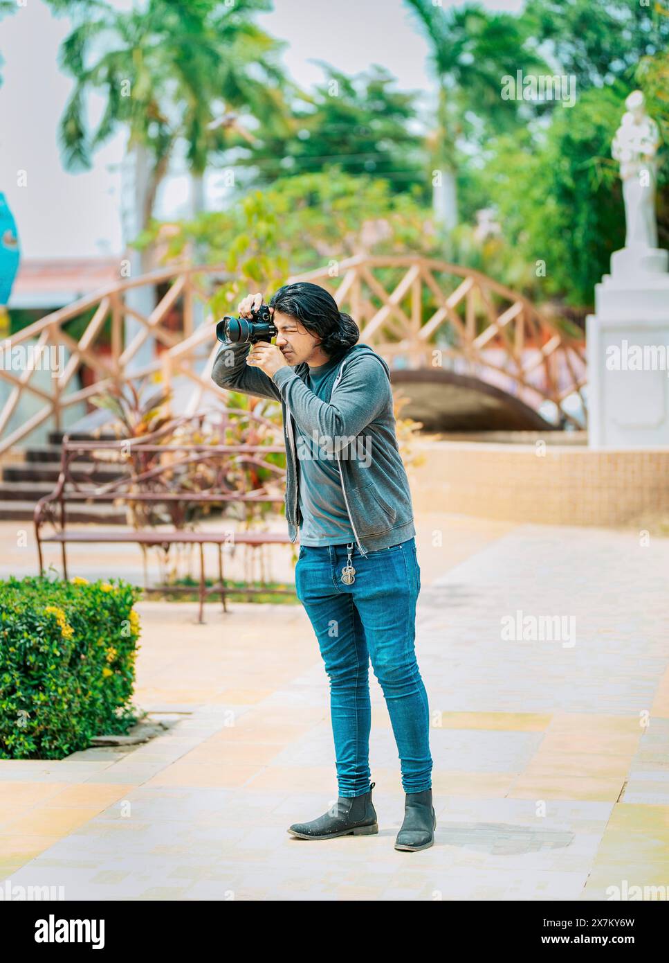 Junger Fotograf, der Fotos auf der Straße macht. Ein Fotograf macht Fotos in einem öffentlichen Park, Nagarote Stockfoto