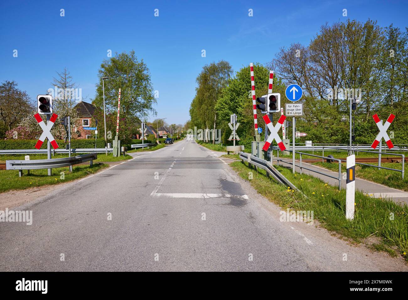 Eingezäunter Bahnübergang mit Andreaskreuzen und Verkehrsampeln für Kraftfahrzeuge in Niebuell, Landkreis Nordfriesland, Schleswig-Holstein Stockfoto