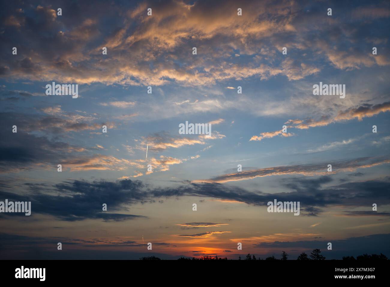 Wunderschöne Sonnenuntergangsszene mit Wolken, die verschiedene Rosa-, Orange- und Blautöne reflektieren. Diese Farben schaffen ein markantes c Stockfoto