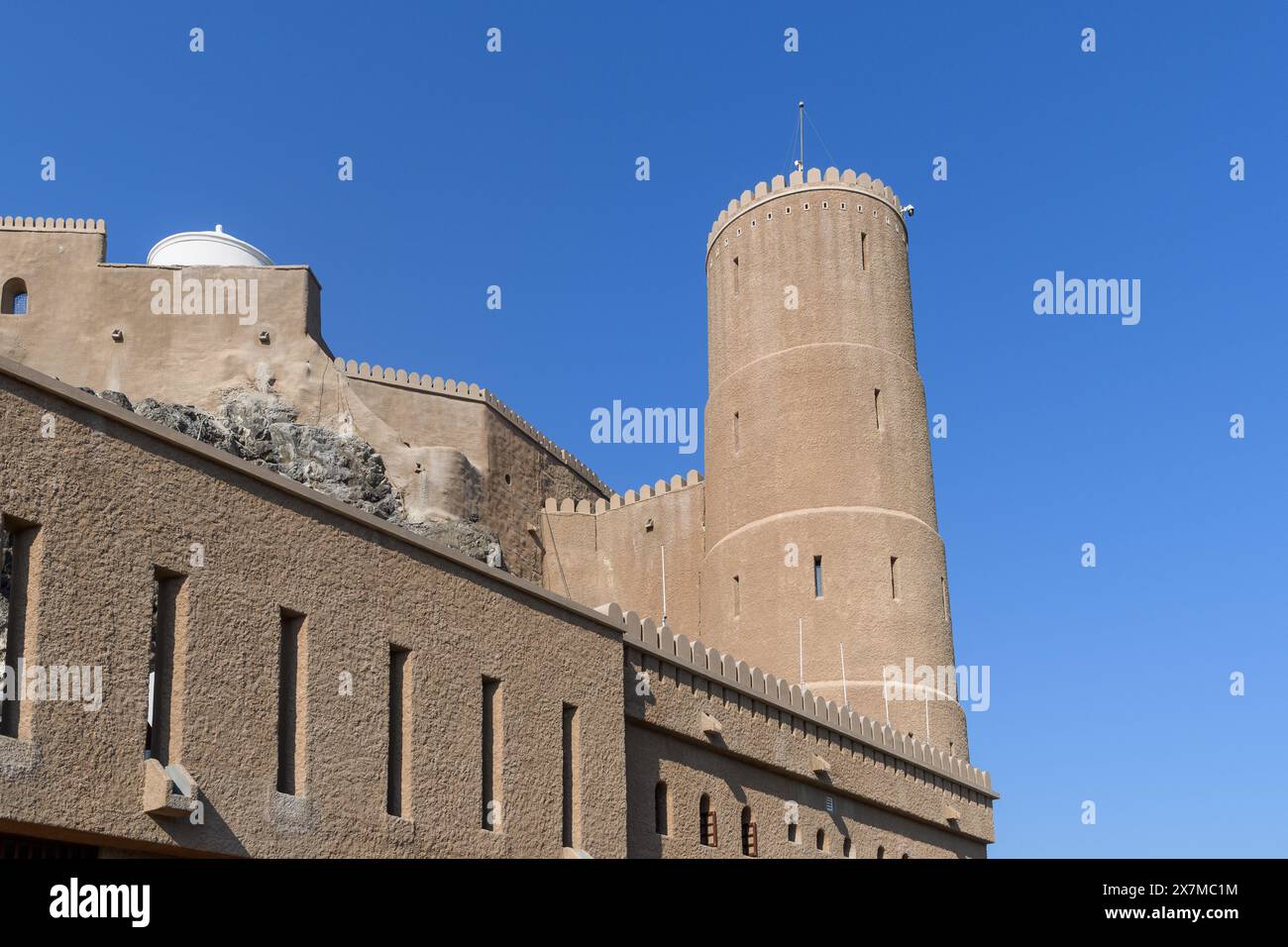 Muscat, Oman - 2. Januar 2024: Eine majestätische Festung steht hoch unter dem klaren blauen Himmel und zeigt die reiche omanische Architektur. Stockfoto