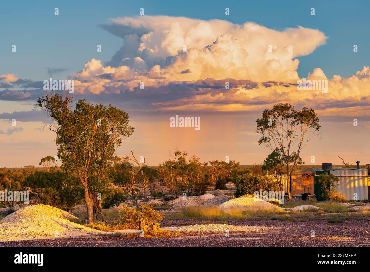 Regen fällt von einer fernen Sturmwolke über einer Bergbaulandschaft am Lightning Ridge im Outback von New South Wales, Australien Stockfoto