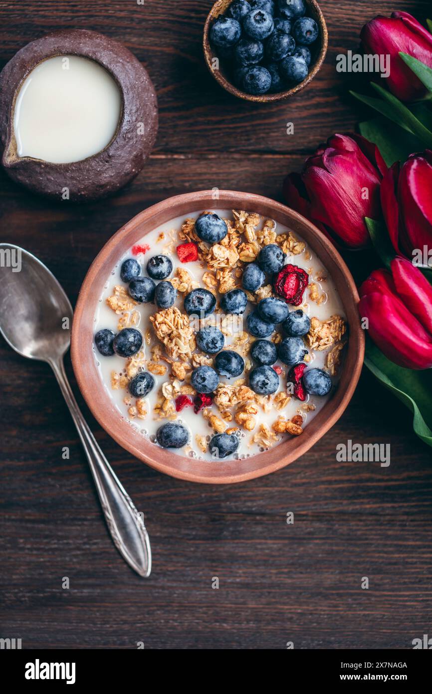 Müsli mit Kirschen und Heidelbeeren in einer Keramikschale Stockfoto