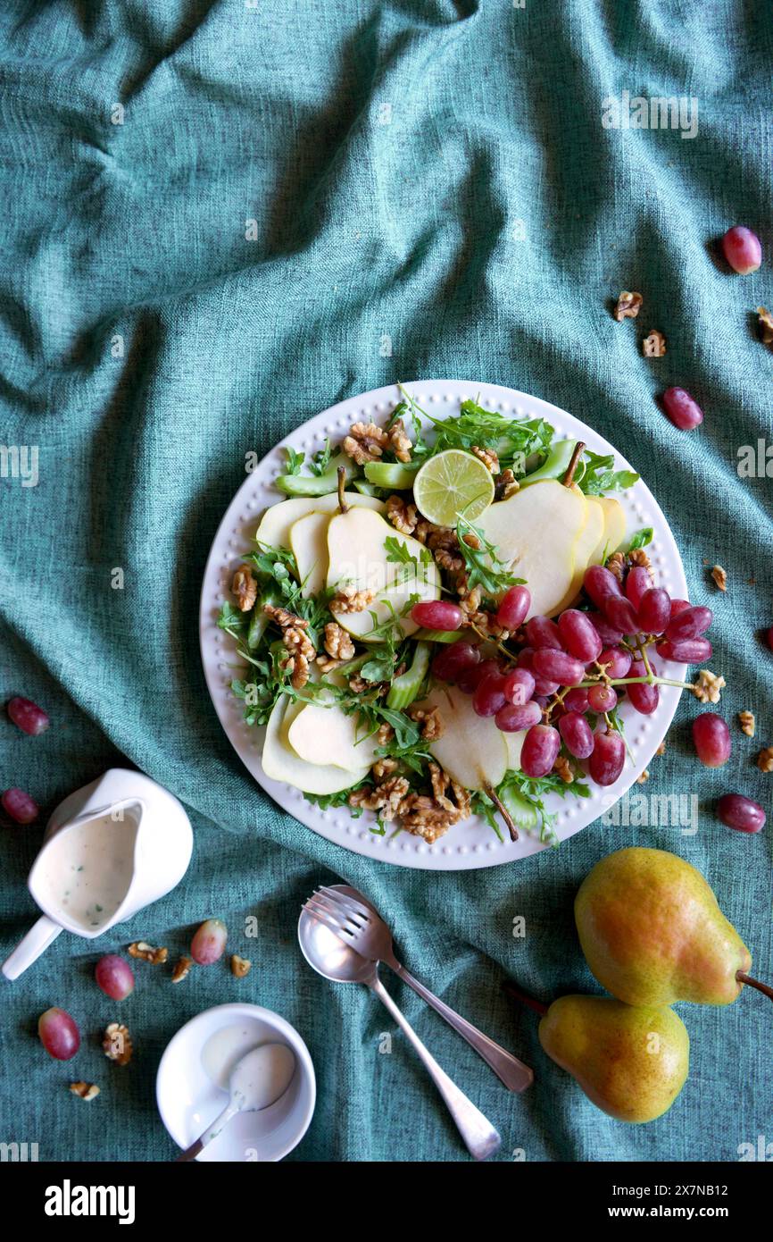 Salat im Waldorfstil mit Birnen, Walnüssen, Sellerie, Trauben und Baby-Raketenblättern. Negativer Kopierbereich. Stockfoto