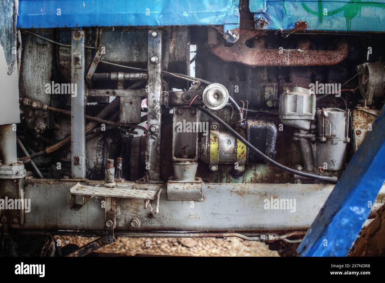 Detail der fettigen Motormechanik eines alten, reparaturbedürftigen Traktors. Stockfoto