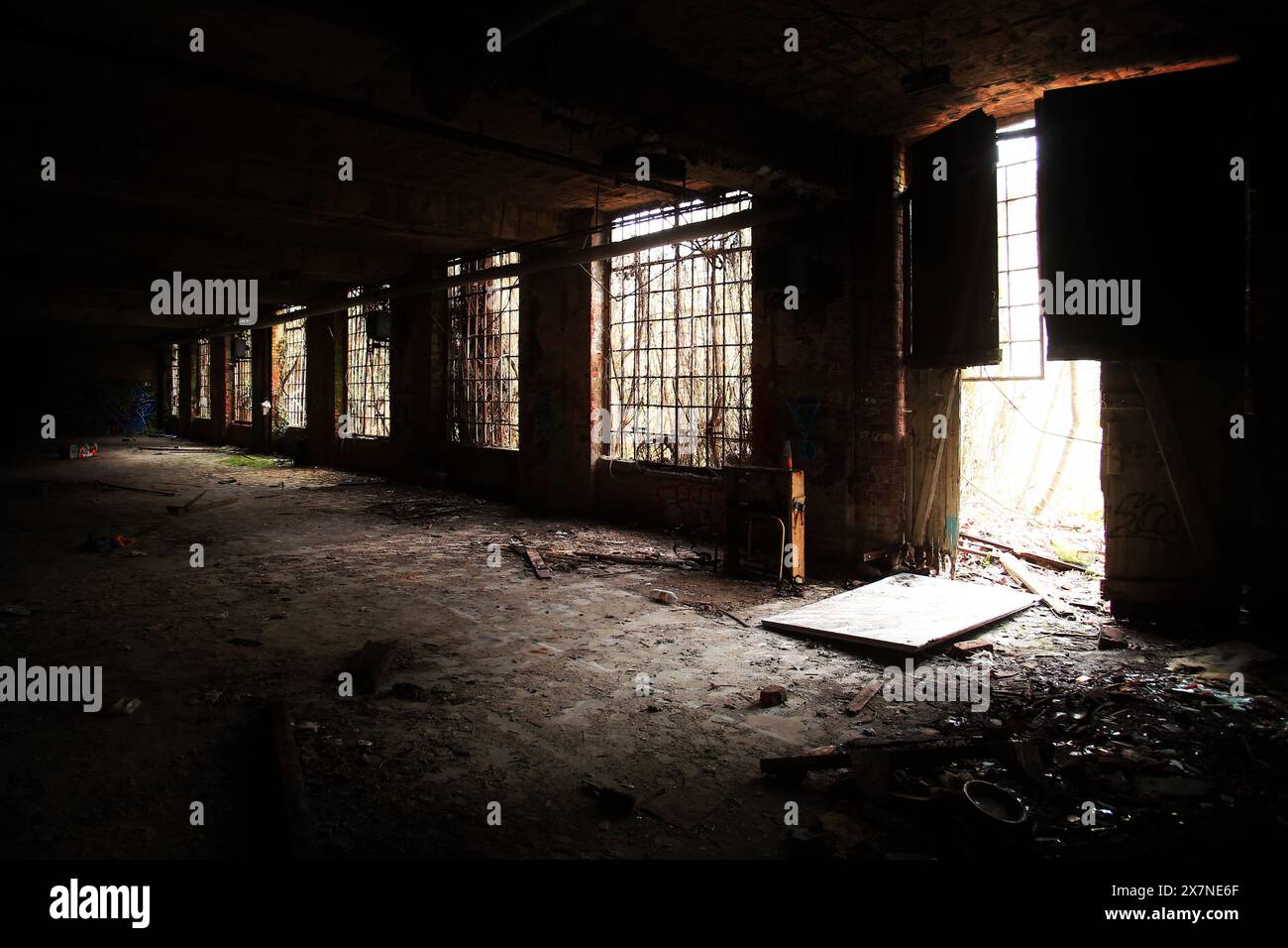 Dunkle Innenaufnahme einer verlassenen Fabrikhalle in Deutschland. Stockfoto