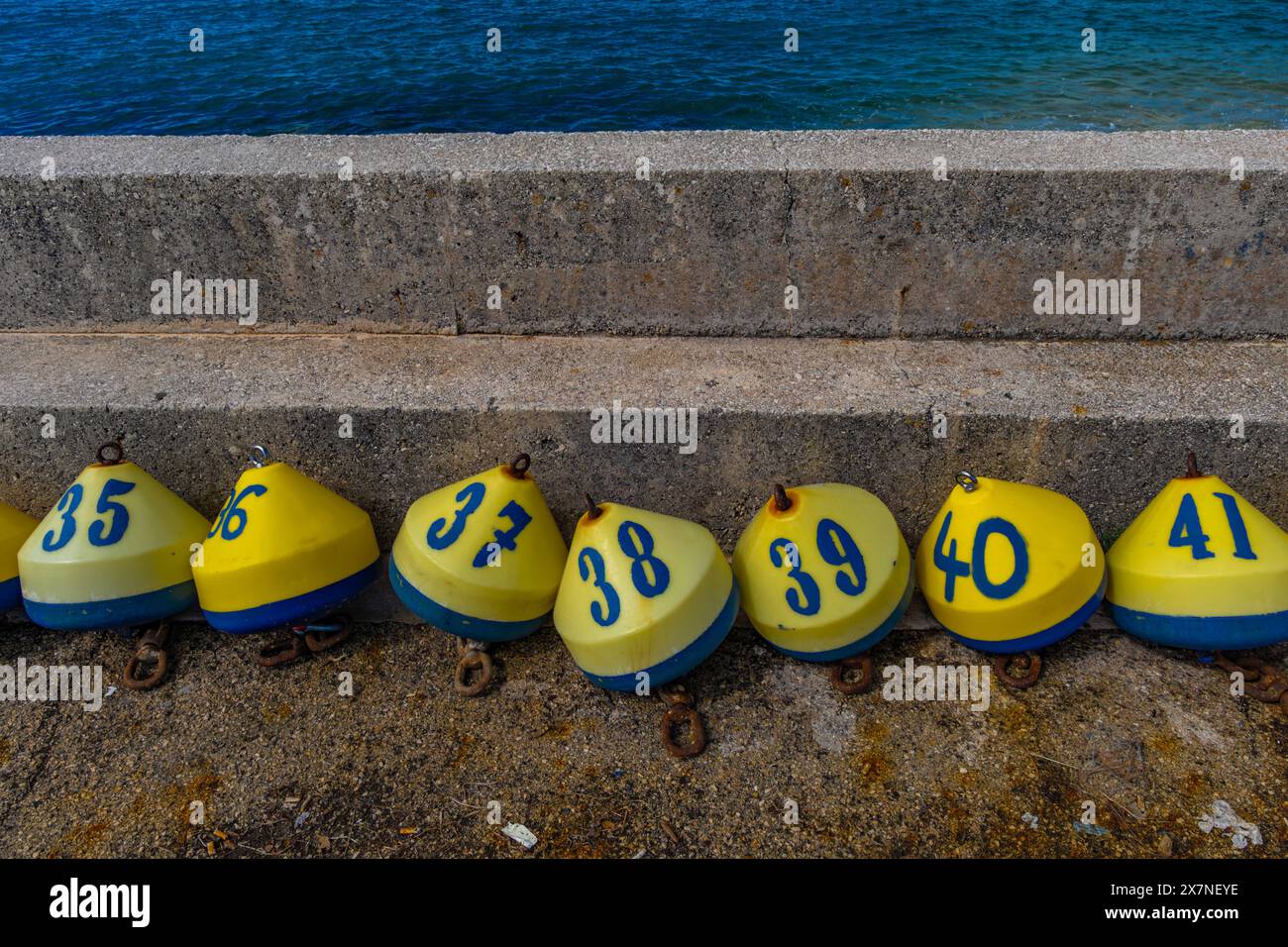 Gewinnung der Lotterie Bunte Bojen mit Zahlen und Buchstaben an der Küste Kroatien Jadran Stockfoto