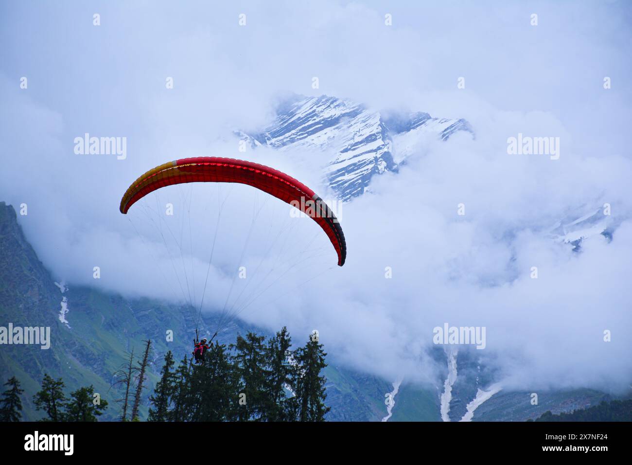 Das wunderschöne Foto zeigt den extremen Sport des Gleitschirmfliegens mit dem wunderschönen und schneebedeckten Himalaya-Gebirge im Hintergrund. Stockfoto
