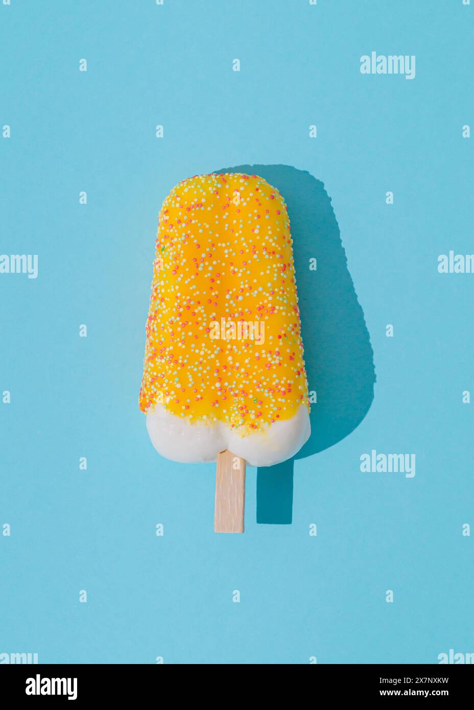 Gelbes Eis-Eis auf hellblauem Hintergrund. Minimales Sommerkonzept. Eisästhetik. Flache Lagen. Stockfoto