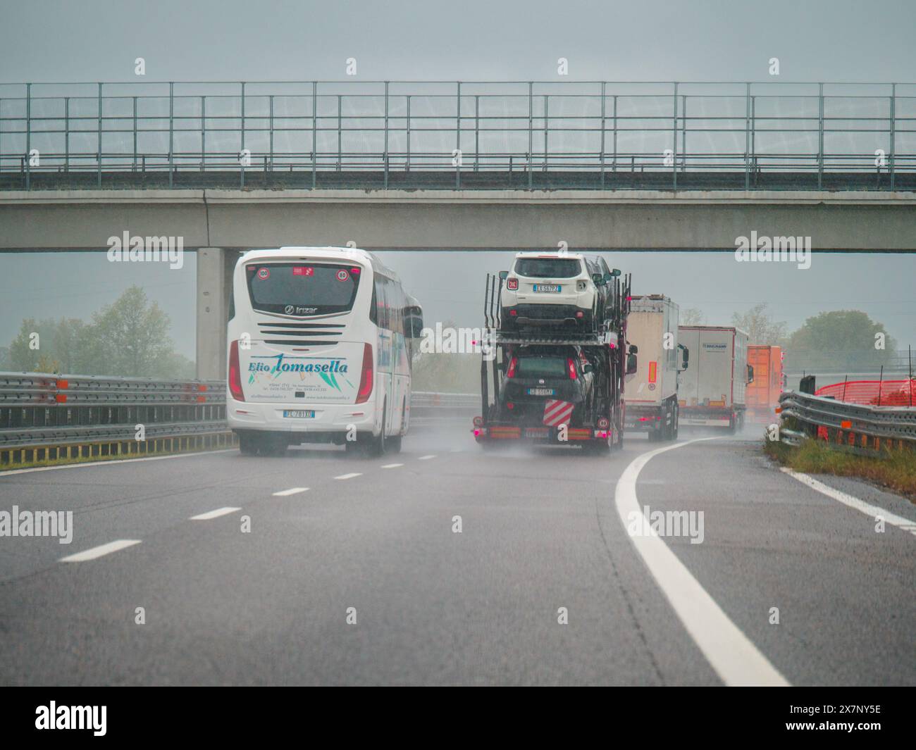 Piacenza, Italien - 22. April 2024 Eine Autobahnszene unter bewölktem Himmel mit Autos und Lastwagen mit Straßenschildern und einem regnerischen Tag auf Motorwa Stockfoto