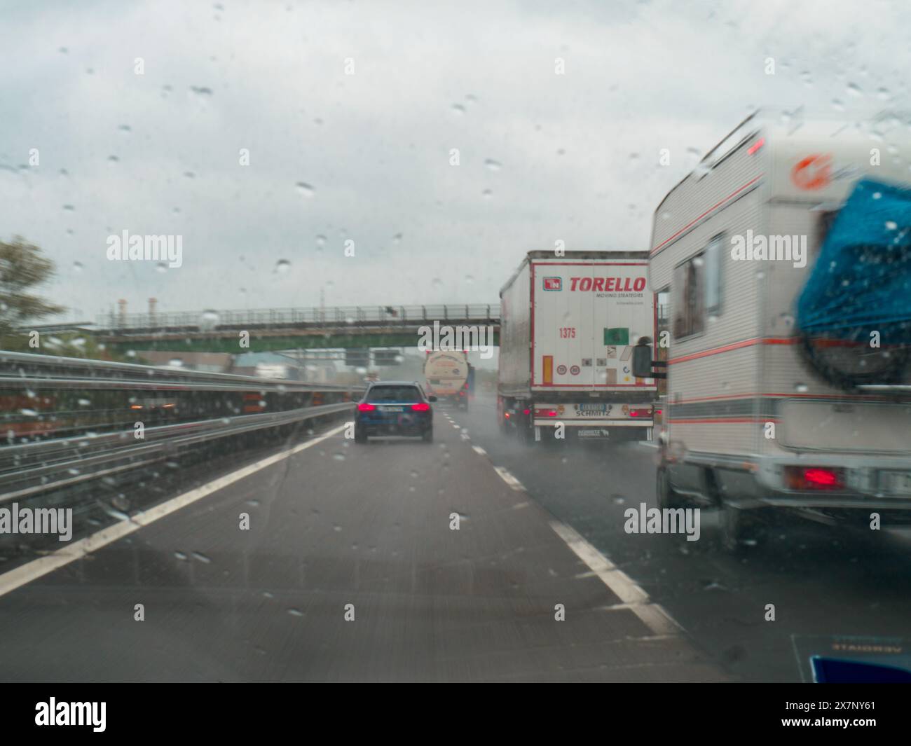 Piacenza, Italien - 22. April 2024 Eine Autobahnszene unter bewölktem Himmel mit Autos und Lastwagen mit Straßenschildern und einem regnerischen Tag auf Motorwa Stockfoto