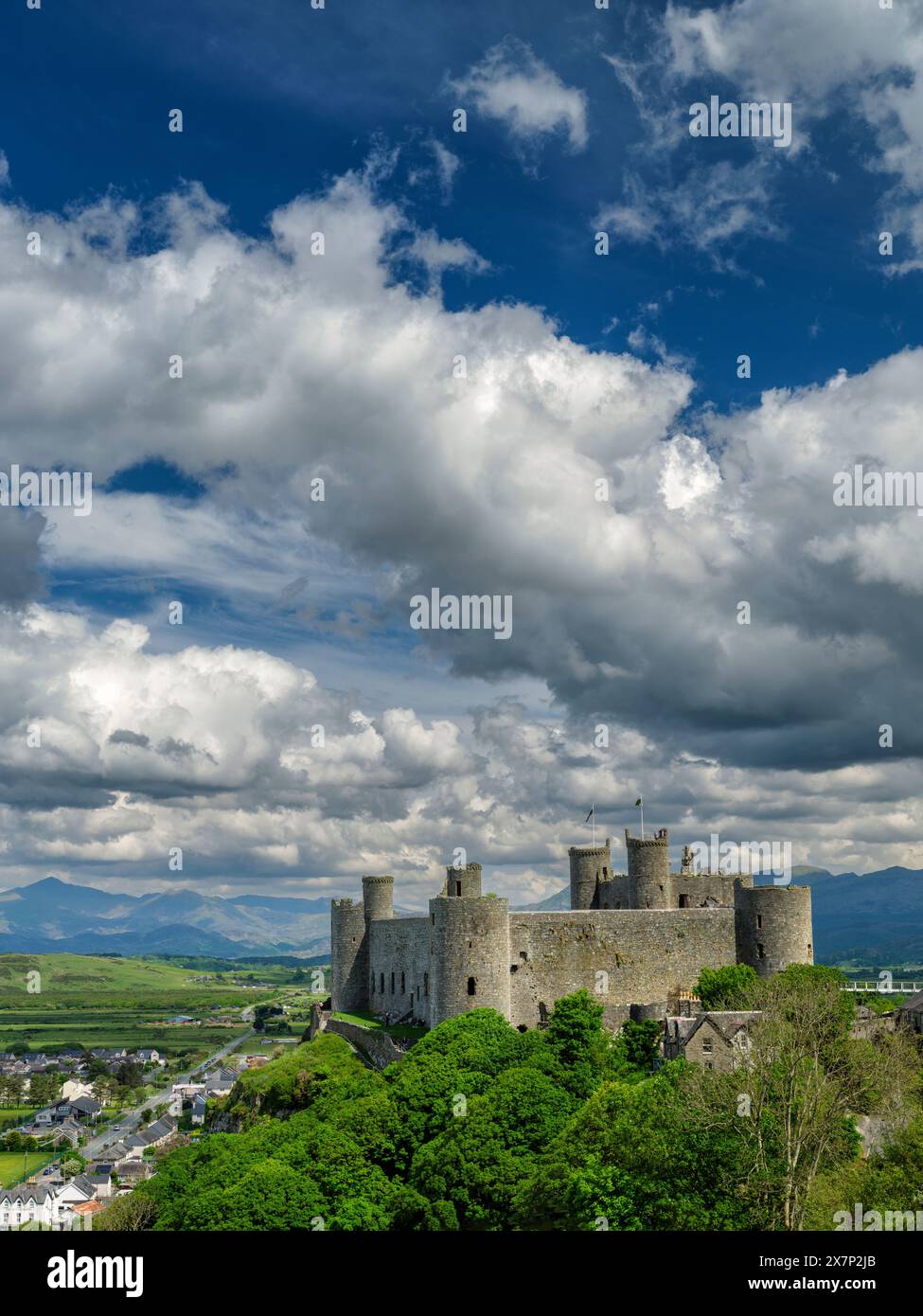 Das Schloss Harlech wurde in den 1280er Jahren erbaut und steht auf einer hohen Klippe und wurde an einem atemberaubenden klaren Sommertag mit dramatischen Wolken und tiefblauem Himmel fotografiert. Stockfoto