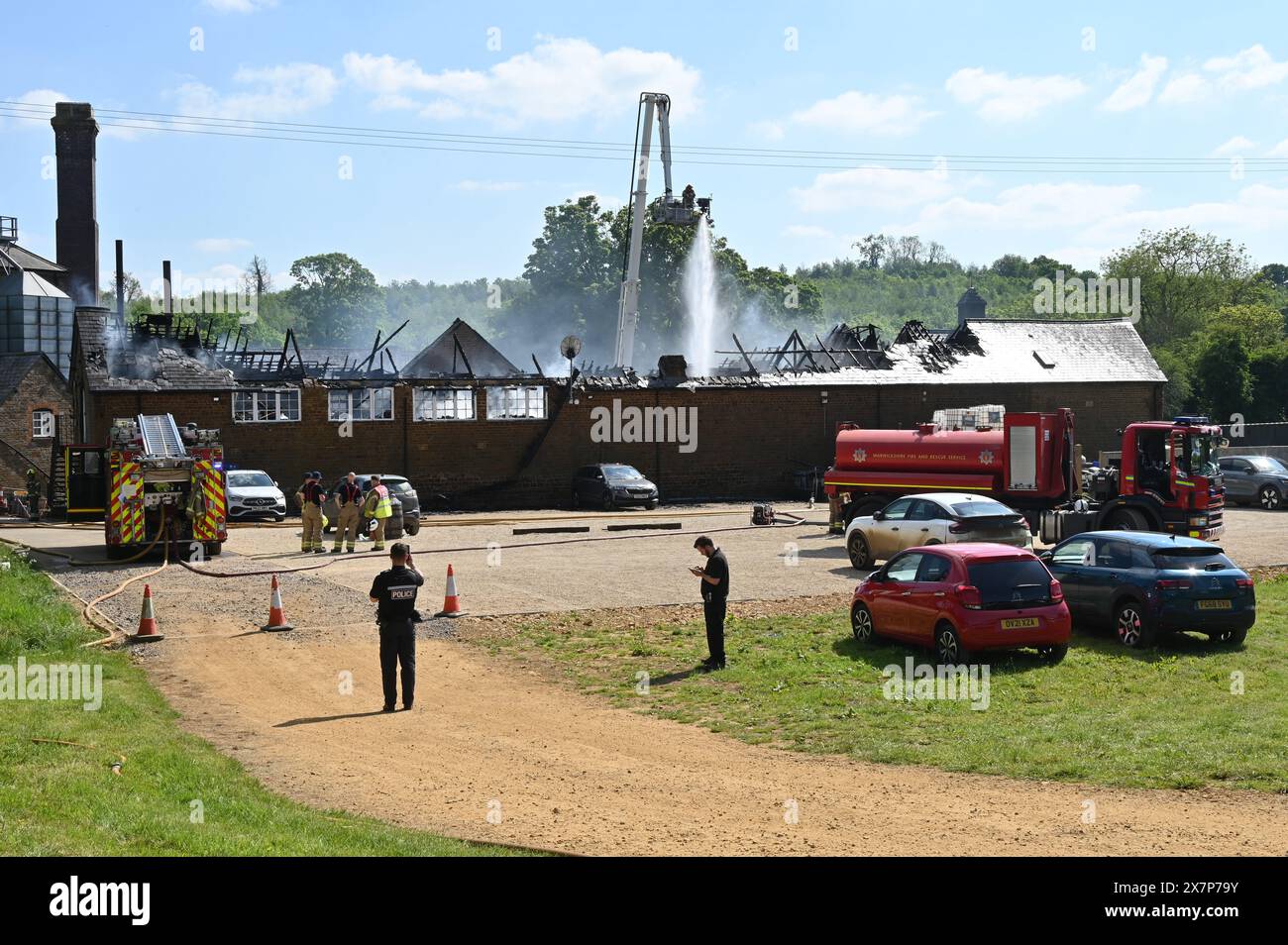 Feuerwehrmannschaften dämpften ein Feuer, das sich in Büros über dem Stallblock der Brauerei im nördlichen Oxfordshire-Dorf Hook Norton befand. Stockfoto