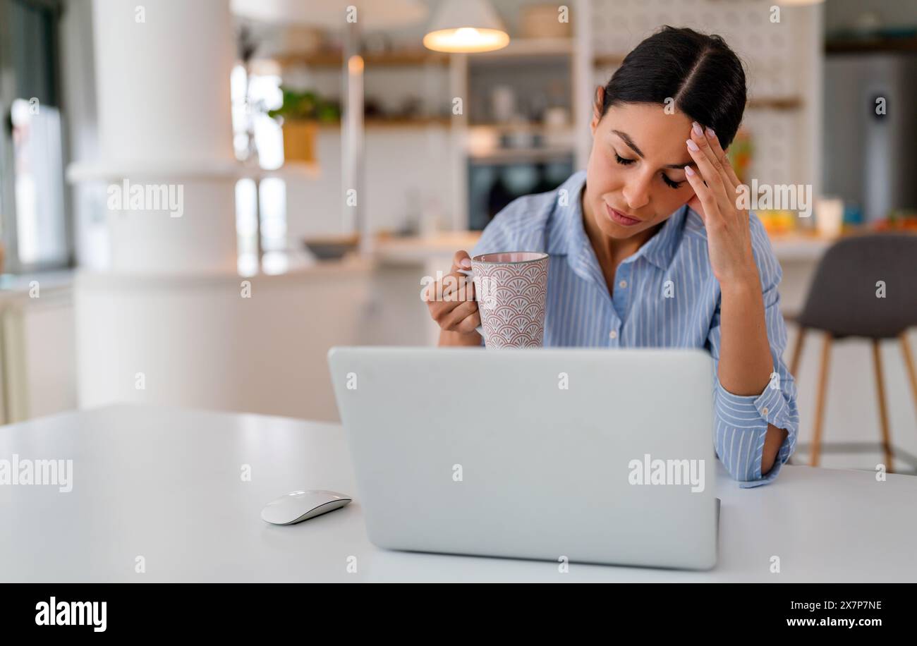 Müde Geschäftsfrau schläfrig und gelangweilt vom Sitzen am Schreibtisch für eine lange Zeit und hat ein Bürosyndrom Stockfoto