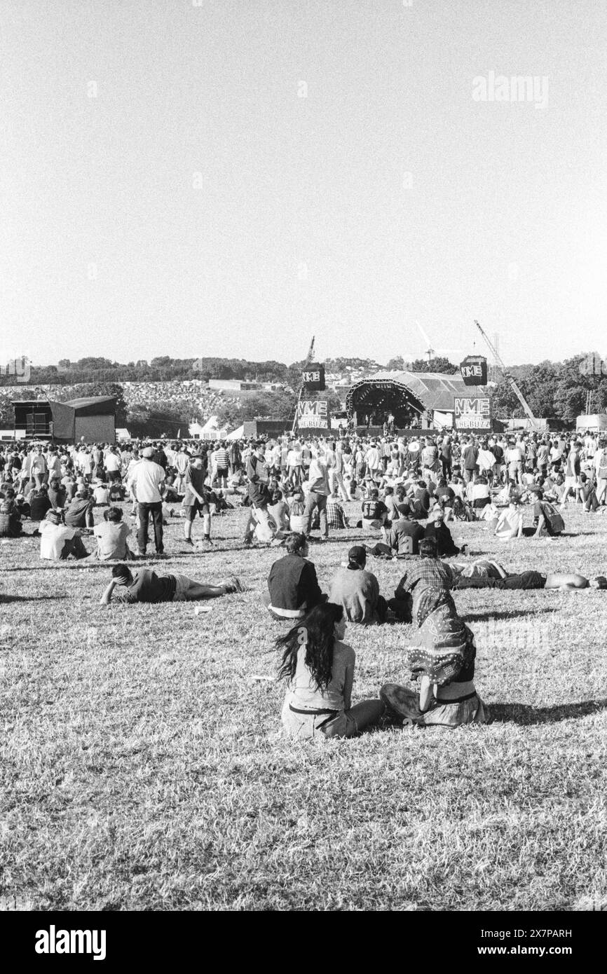 CROWD, HEATWAVE, NME STAGE, GLASTONBURY 95: Ein weiter Blick aus dem hinteren Teil des Feldes, während Festivalbesucher in der extremen Sommerhitze auf dem Gras beim zweiten NME Stage Field und Crowd beim Glastonbury Festival, Pilton Farm, Somerset, England, 24. Juni 1995. 1995 feierte das Festival sein 25-jähriges Bestehen. Viele Menschen hatten an dem besonders heißen Wochenende Probleme mit dem Hitzschlag. Foto: ROB WATKINS Stockfoto