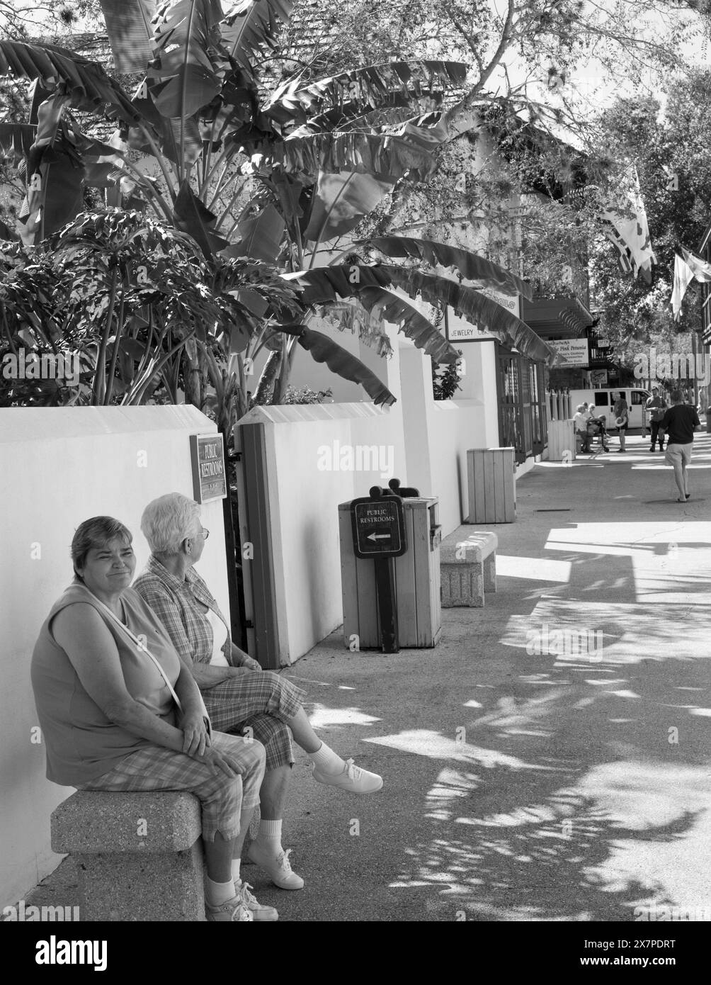 Zwei weibliche Touristen ruhen sich auf einer Bank an der St. George Street in St. Augustine, Florida, USA aus. Stockfoto