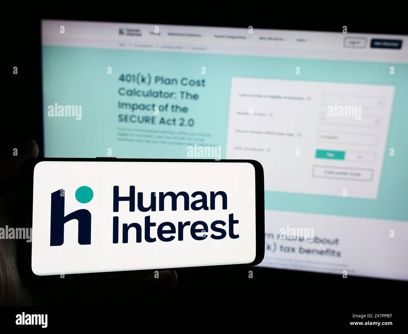 Person mit Smartphone und Logo des US-Finanzdienstleisters Human Interest Inc. Vor der Website. Schwerpunkt auf dem Display des Telefons. Stockfoto