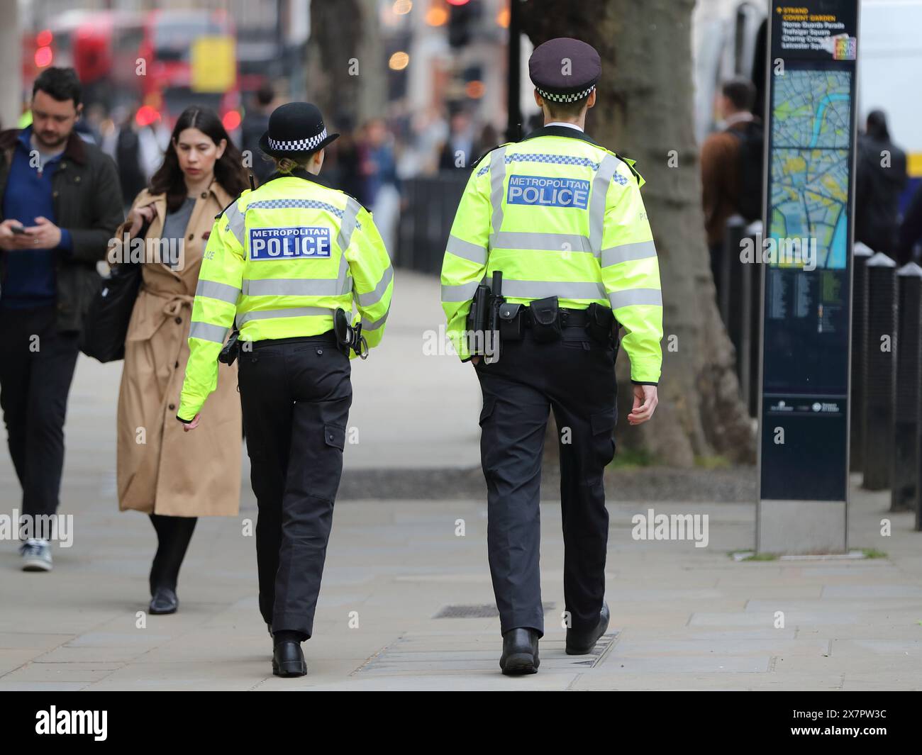 Ein männlicher und eine weibliche Polizistin patrouillieren Whitehall, London, Großbritannien Stockfoto