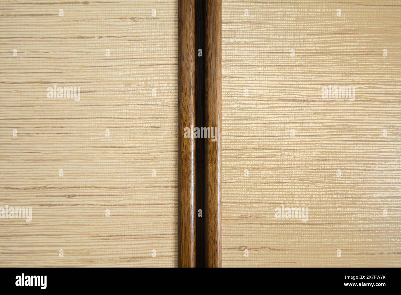 Eine helle Holztafel mit horizontaler Körnung, geteilt durch einen dunkleren vertikalen Streifen. Klares, einfaches Design mit natürlicher Holzstruktur. Stockfoto