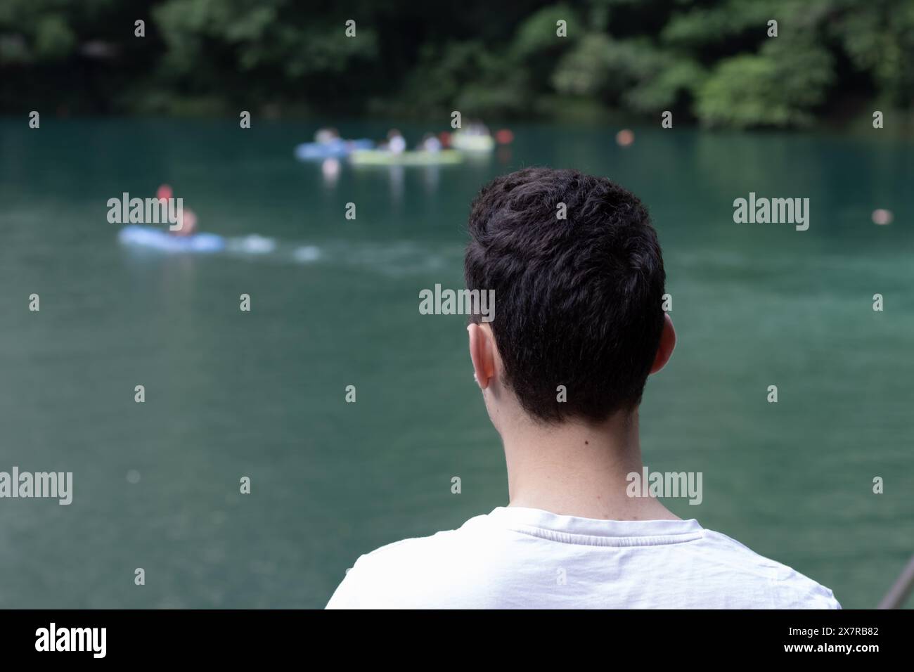 Junger Mann im Fokus, der auf nautische Aktivitäten schaut. Sonniger Tag in der Matka-Bergschlucht. Stockfoto