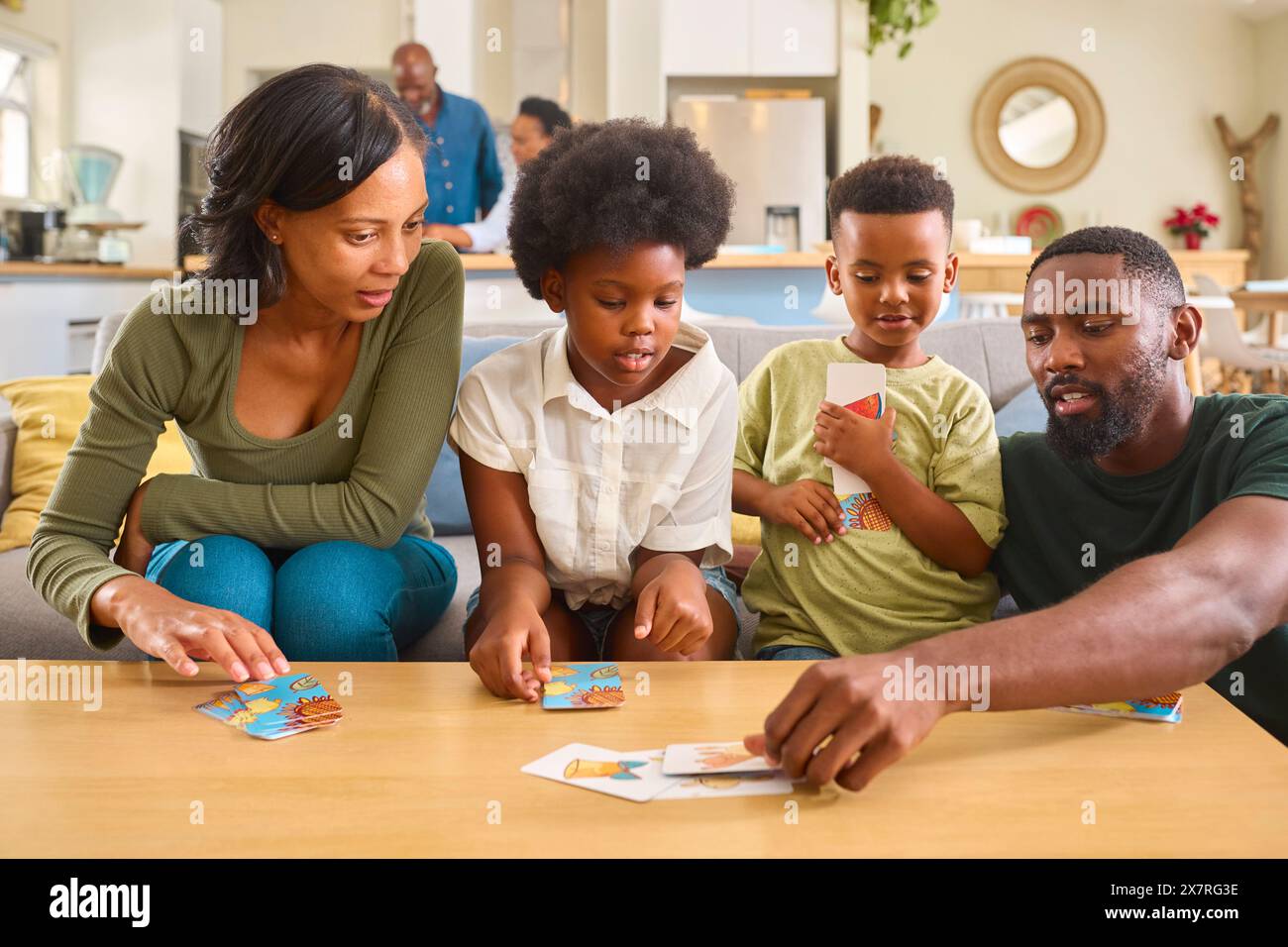 Familie Zu Hause Mit Spielkarten Mit Großeltern Im Hintergrund Stockfoto