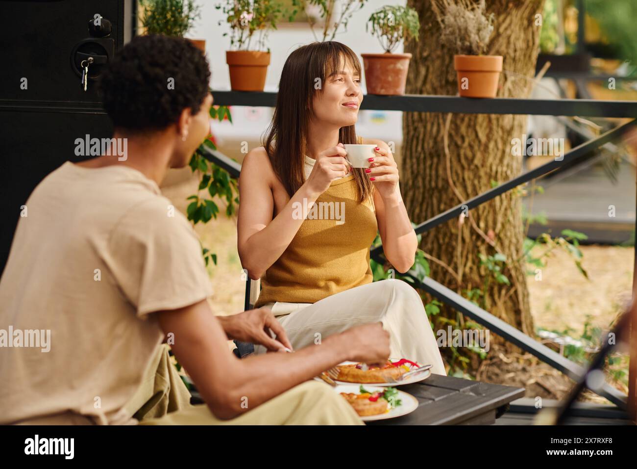 Ein Mann und eine Frau genießen einen friedlichen Moment auf einer Bank und genießen Tassen Kaffee in Gesellschaft. Stockfoto
