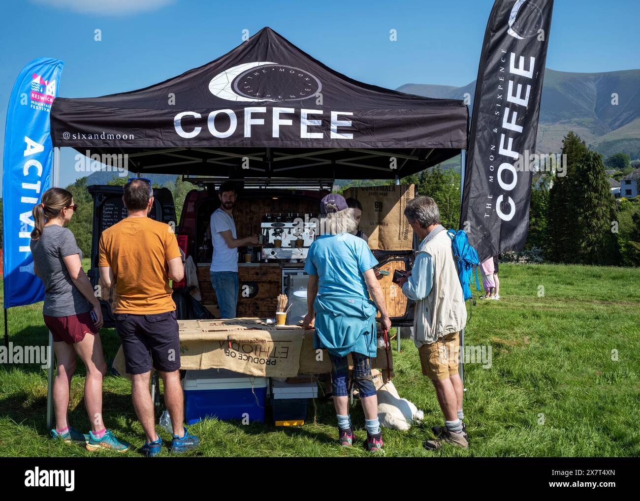 Kunden im „Moon and Sixpence“ Kaffeevollbus mit Skiddaw im Hintergrund, Crow Park, Keswick, Lake District National Park, Cumberland, Großbritannien Stockfoto