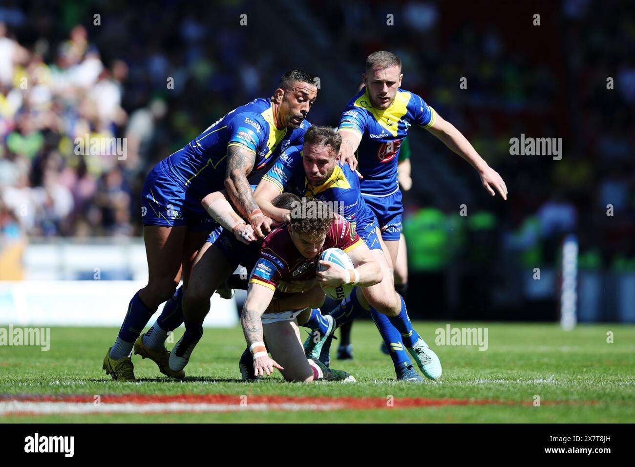 Elliot Wallis der Huddersfield Giants wird im Halbfinalspiel des Betfred Challenge Cup im Totally Wicked Stadium in St Helens gegen Paul Vaughan, James Harrison und Ben Currie von Warrington Wolves angegriffen. Bilddatum: Sonntag, 19. Mai 2024. Stockfoto