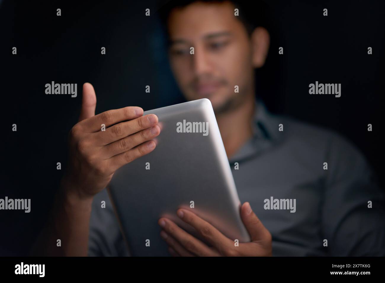 Mann, dunkler Hintergrund und Tablet für Cybersicherheit mit Software-Update zum Schutz vor Betrügern. Cyberkriminalität, digitale App und Internetverbindung ein Stockfoto